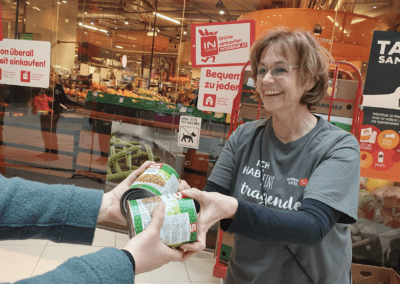 Ehrenamtliche nimmt beim TafelSammeltag Spenden entgegen